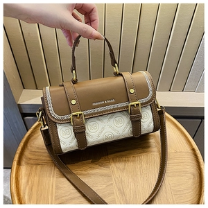 Dettaglio della borsa a tracolla monogramma marrone e bianca con fibbia dorata e manico