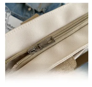 Detail showing the smooth metal zipper and durable canvas texture of this tote bag