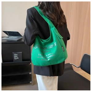 Close-up of vibrant green canvas tote bag featuring stylish printed typography and brand tag