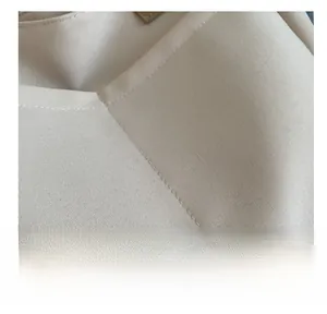 Detail showing high-quality double stitching and canvas fabric texture of the beige tote bag