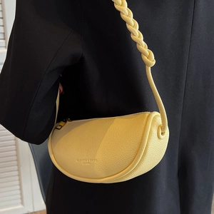 Bright yellow crescent saddle bag with braided shoulder strap and pebbled leather texture