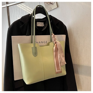 Close-up of sage green tote bag with decorative silk twilly scarf and quilted stitching