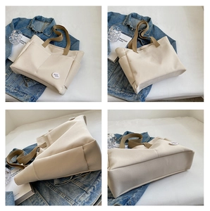 Detail view of cream canvas tote bag with good luck embroidery and side pockets