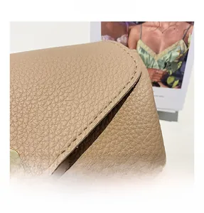 Detailed macro view of beige lychee texture leather and premium gold metal fastener