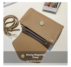 Close-up of litchi texture leather handbag with magnetic buckle and interior organizer