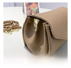 Detail of khaki lychee grain leather bag showing gold hardware buckle and soft texture