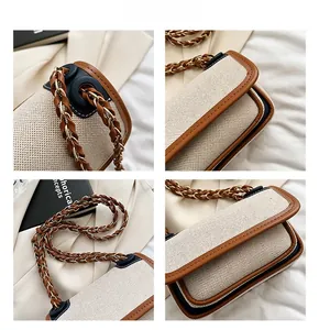 Detail of woven fabric handbag with brown leather trim and metal chain strap