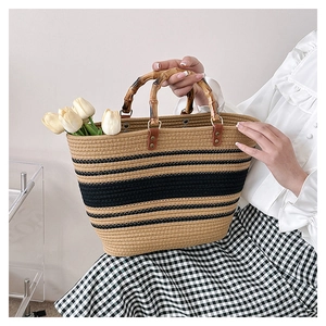 Detailed close-up of natural bamboo handle and striped woven texture on a tote bag