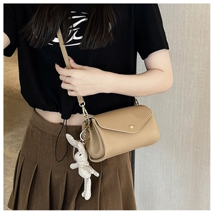 Detail of khaki leather small square crossbody bag with cute plush bunny charm