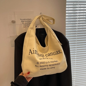 Minimalist off-white canvas hobo tote bag with black letter print and shoulder strap
