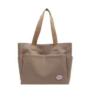 Minimalist canvas tote bag with multi-pocket design and reinforced handles in khaki color