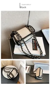Detail of the vintage canvas square bag featuring black leather trim and chain strap