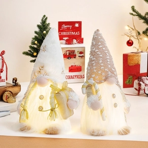 Close-up of glowing LED Christmas gnomes with knit hats and warm festive lights