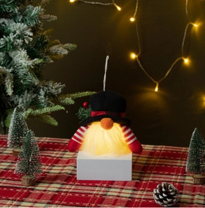 Close-up of glowing Christmas gnome plush with LED light and festive knitting details