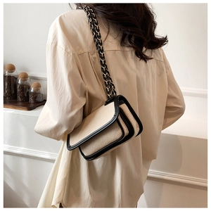 Detailed back view of vintage beige woven crossbody bag with black leather trim and chain