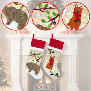 Detail view of bear and fox embroidery on white Christmas stockings with red velvet cuff