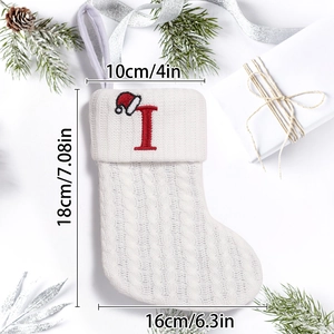 Dettaglio calza di Natale in maglia a trecce bianca con lettera I rossa e dimensioni