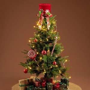 Close-up of red velvet top hat Christmas tree topper with ribbon and festive ornaments