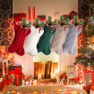 Juego de cinco calcetines de Navidad de punto trenzado clásico colgados junto a la chimenea