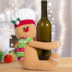 Gingerbread man wine bottle cover with chef hat and striped scarf on festive table