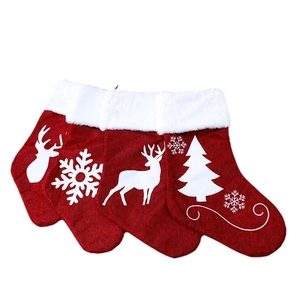Three red Christmas stocking set with white snowflake reindeer and tree patterns
