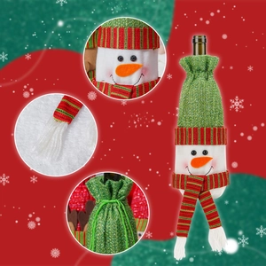 Detail of knitted snowman wine bottle cover with red and green striped scarf and hat