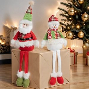 Christmas plush Santa and snowman long-legged figurines on a gift box background