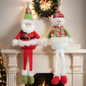 Close-up of plush long-legged Santa and Snowman dolls on a decorated Christmas fireplace