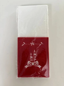 Close-up of red felt cutlery pouch with white Christmas candle and snowflake embroidery