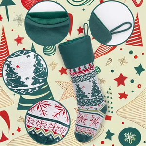 Close-up of festive knit Christmas stocking with tree patterns and soft green plush lining