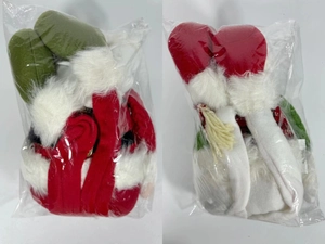 Detail of two Christmas plush gnome ornaments in protective plastic packaging