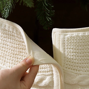 Detalle de la falda para árbol de Navidad de punto blanco con cierre de velcro ajustable
