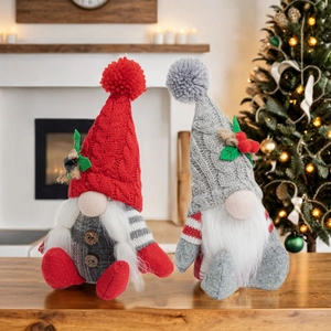 Detail of two Christmas gnomes with knitted hats and white beards on a wooden table