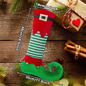 Elf theme Christmas stocking with bells and stripes on a rustic wood background