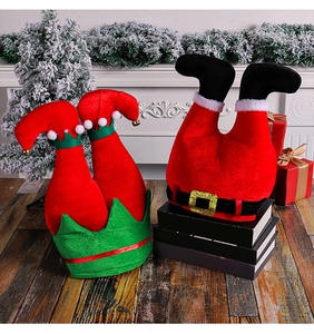 Feestelijke pluchen kerstelfbenen en kerstmandecoraties bij de witte open haard