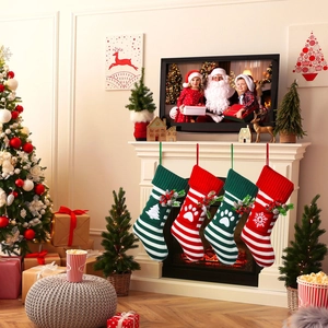 Cozy knit Christmas pet socks with festive snowflake and paw patterns hanging by fireplace