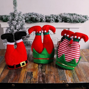 Three decorative Christmas party hats with Santa and elf inverted legs on a wooden table