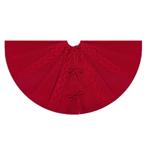 Classic red cable knit Christmas tree skirt with ribbon ties on a white background
