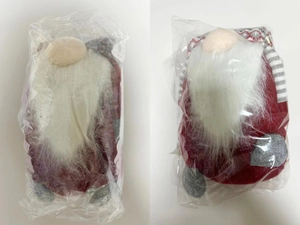 Detail of Christmas gnome plush dolls in plastic packaging with white beards and red hats