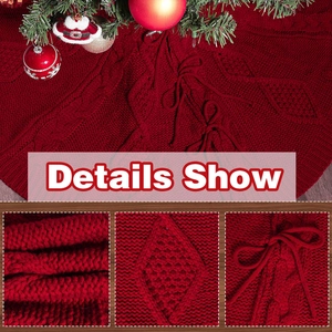 Details der roten gestrickten Weihnachtsbaumdecke mit Zopfmuster und dekorativen Schleifen