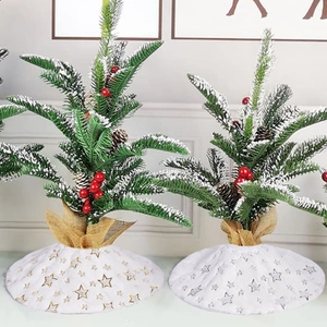 Miniature Christmas trees with faux snow, red berries, and star pattern tree skirts