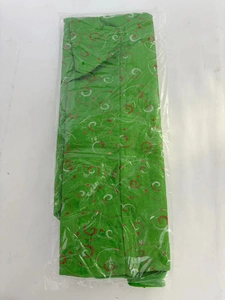 Macro detail of textured green fabric with red and white spiral patterns in package