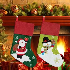 Detail of Christmas stockings with Santa and Snowman embroidery hanging on fireplace