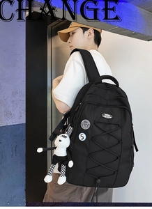 Détail d'un grand sac à dos en nylon avec écussons brodés et pendentif lapin à carreaux chic