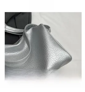 Detail shot of silver textured faux leather material on a large capacity shoulder bag