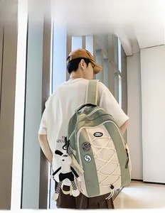 Vue latérale d'un grand sac à dos en nylon beige et vert porté par un mannequin