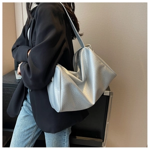 Close-up of silver embossed leather texture on a spacious tote bag for women