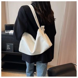 Detail of white large capacity hobo bag with textured pebble leather and soft slouchy shape