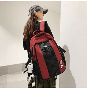 Détail du sac à dos en nylon rouge et noir avec cordons élastiques et porte-clé lapin