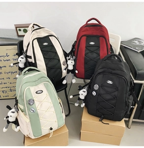 Détail de quatre sacs à dos en nylon colorés avec fermetures éclair et pendentifs chien